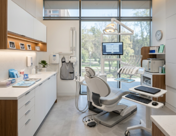 Dental office with a dental chair, overhead light, computer screen, and dental instruments